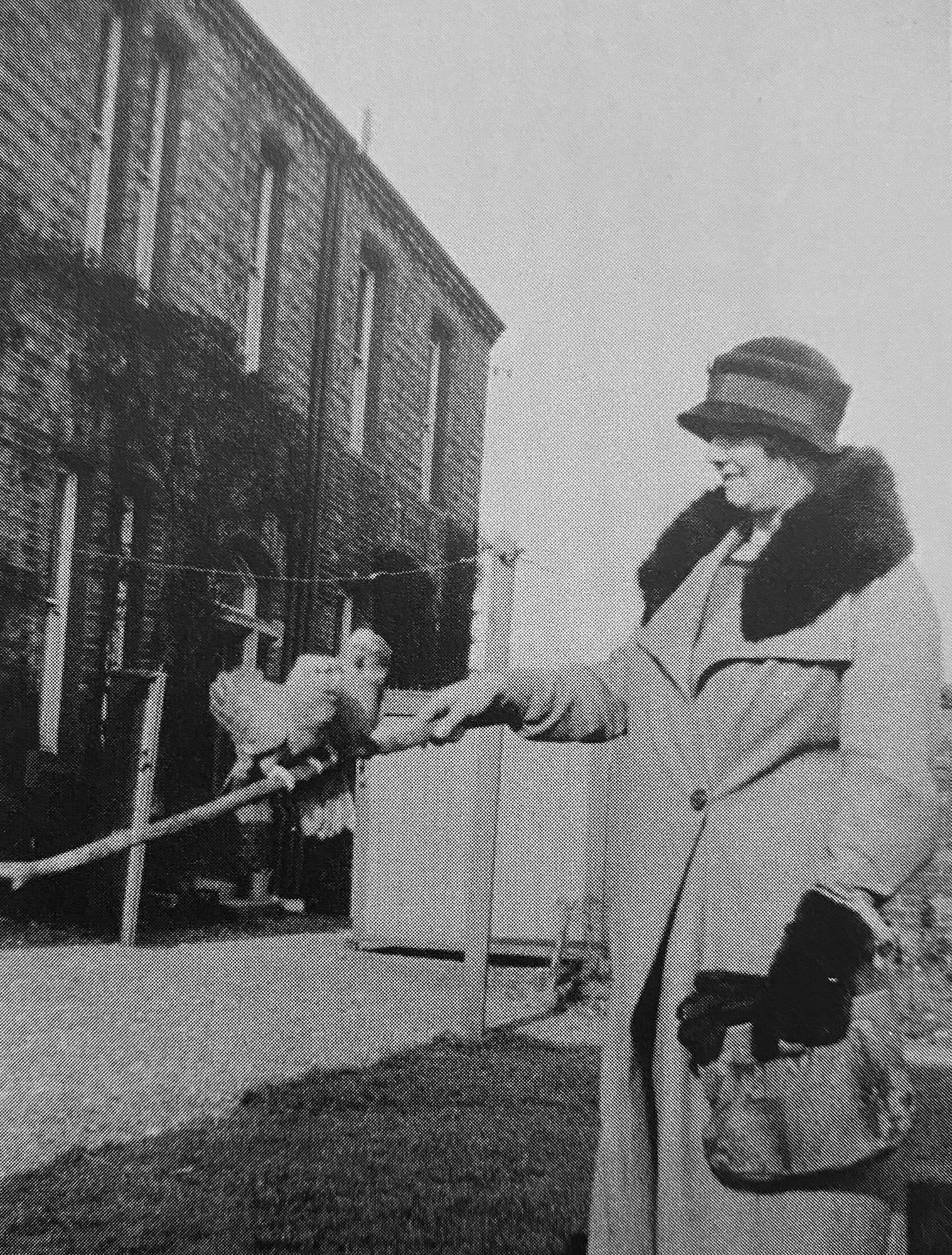 Mrs Ethel Harris standing outside the Infectious Diseases Hospital with two parrots belinging to the matron, Mrs Fox.